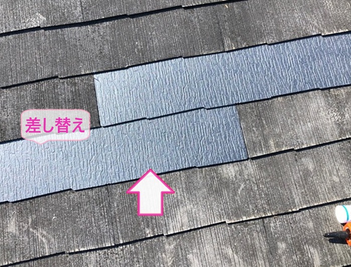 3階建て平型スレート屋根の補修工事で屋根材を差し替えている様子