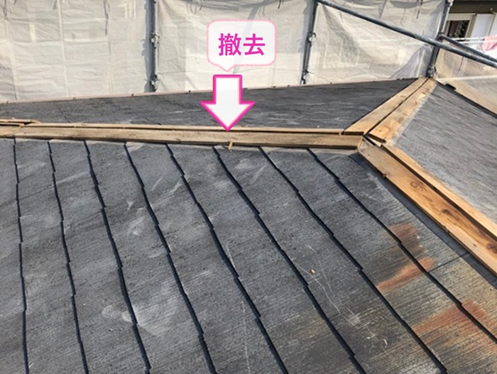 3階建て平型スレート屋根の補修工事で既存の棟板金を撤去している様子