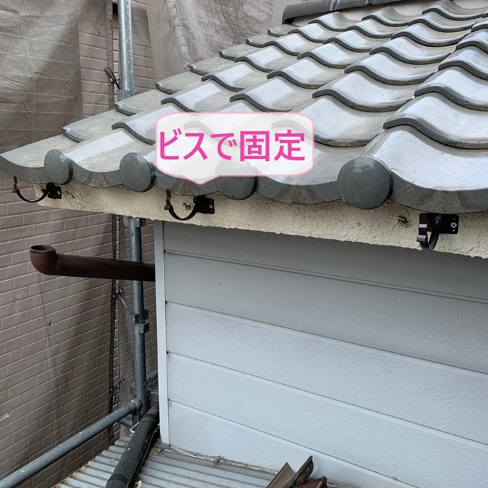 神戸市垂水区で半丸雨樋の受け金具をビスで固定している様子