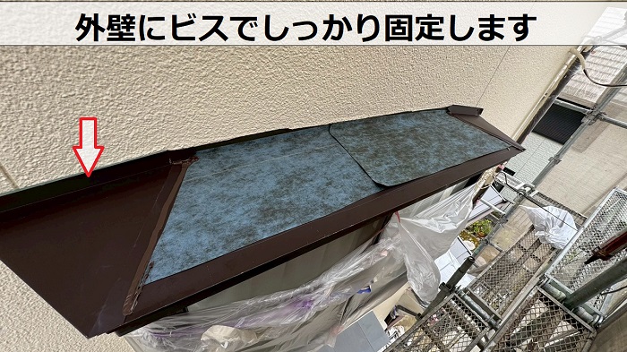 外壁にビスで固定します