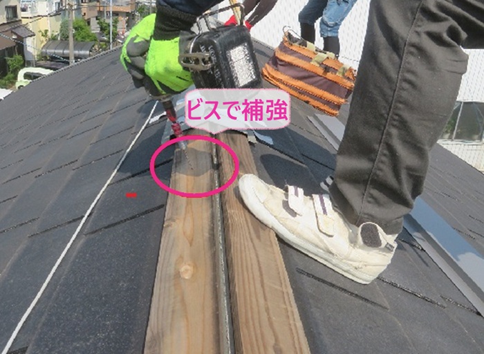 強風被害で落下した屋根板金の部分補修で下地木材にビスを打って補強している様子