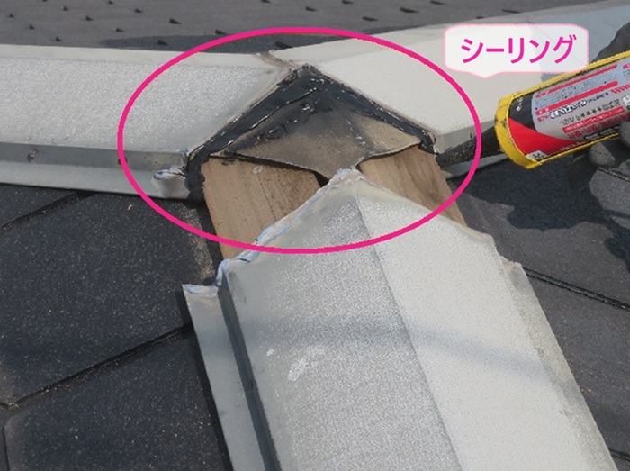 強風被害で落下した屋根板金の部分補修でジョイント部分にシーリングを挟み込んでいる様子