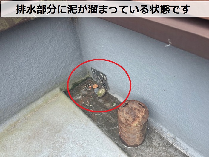 屋上のFRP防水の排水部分に泥が溜まっている様子