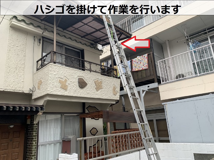 屋根にハシゴを掛けている様子