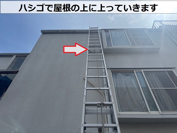 ハシゴで屋根の上に上がっている様子