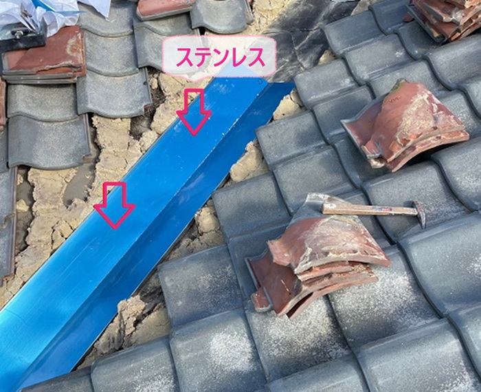 瓦屋根の谷部のリニューアル工事でステンレス板に入れ替えてる様子