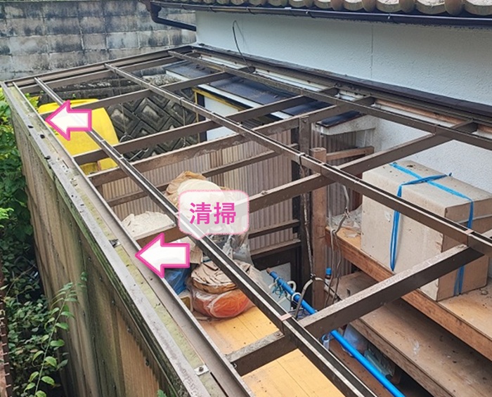 資材置き場屋根の波板交換で既存のアルミ下地の雨樋を掃除している様子