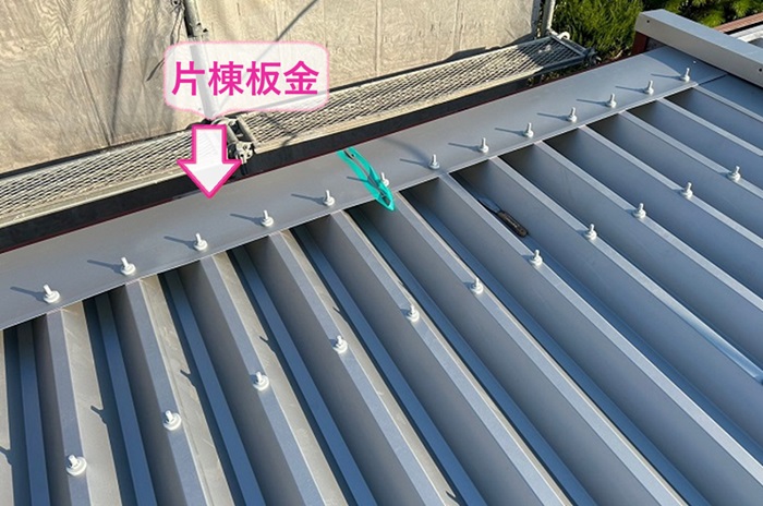 折板屋根の重ね施工で水上部分に片棟板金を取り付けている様子