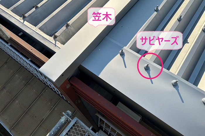 折板屋根の重ね施工で笠木とサビヤーズを取り付けている様子