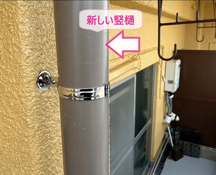 雨樋縦パイプの交換修理で新しい竪樋を取り付けている様子