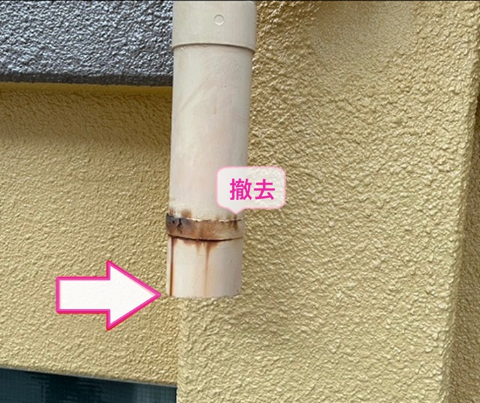 劣化した雨樋縦パイプの交換修理で既存の竪樋と固定バンドを撤去している様子