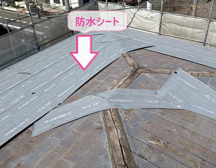 建物の屋根改修工事で防水シートを貼っている様子