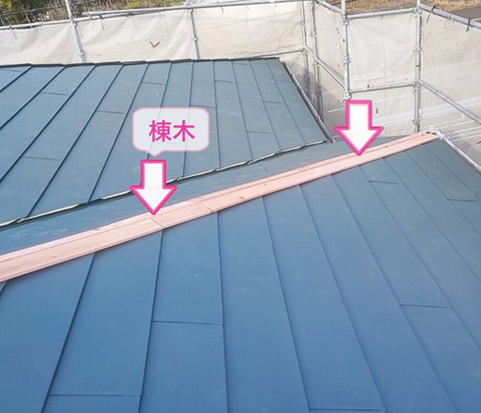 店舗建物の屋根改修工事で棟木を取り付けている様子