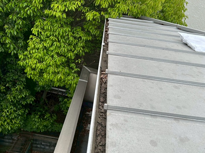 宝塚市で雨樋からの水漏れを解消するために落ち葉除けネットを取り付ける前の様子
