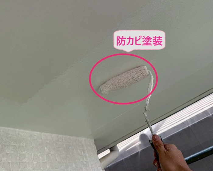 木造2階住宅の外装改修で軒天に防カビ塗装をしている様子