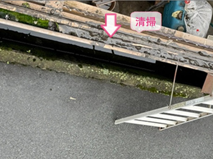 ストックヤード屋根の波板張り替えで雨樋を掃除している様子