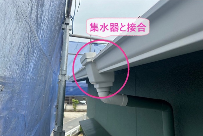 アパートの軒どい交換工事で集水器を取り付けて竪樋と接合している様子