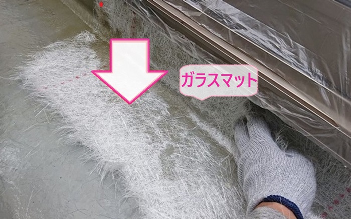 2階バルコニーの雨漏り修理でFRP防水のガラスマットを敷いている様子