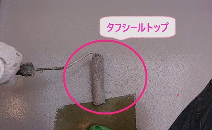 バルコニー防水工事の仕上げにタフシールトップを塗っている様子