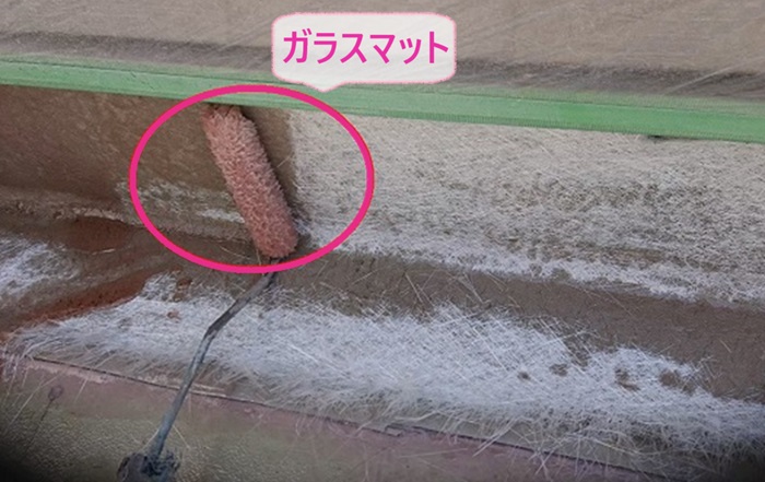 バルコニー防水工事で新しいガラスマットを貼っている様子