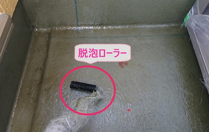 タフシールを用いたバルコニーFRP防水工事で脱泡ローラーで気泡を抜いている様子