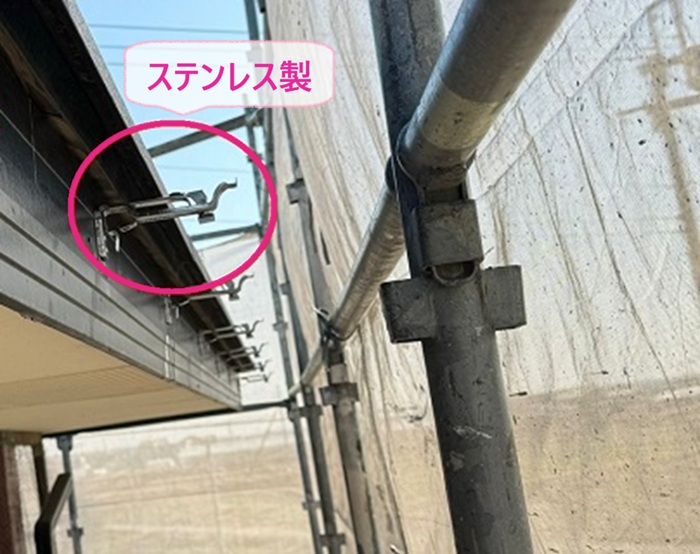 軒樋交換工事で新しいステンレス製の固定金具を取り付けている様子