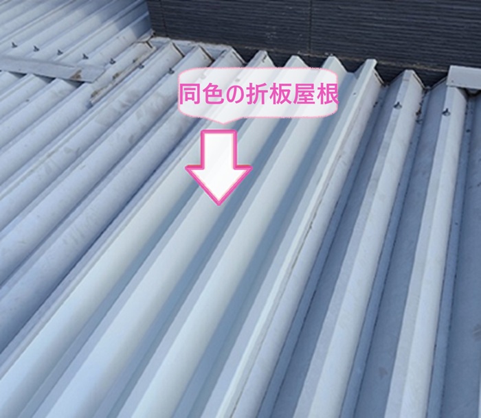 車庫の金属折板の張り直しで新しく同色の折板屋根を取り付けている様子