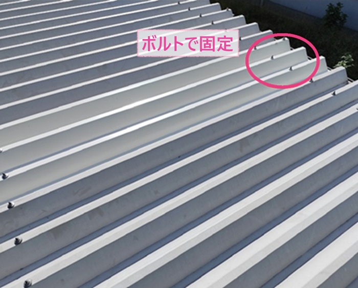 車庫の金属折板の張り直しで折半屋根をボルトで固定している様子