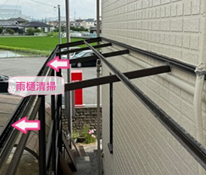 物置スペースの波形屋根張り直しで雨樋清掃している様子