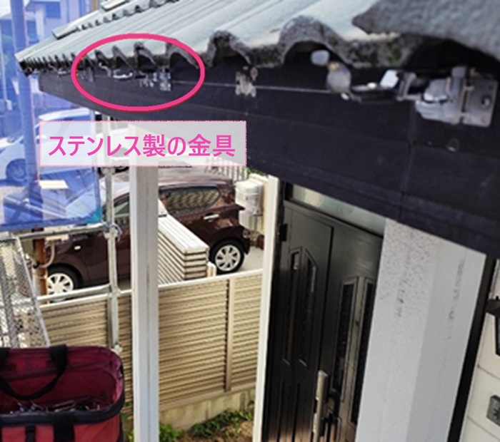 穴の空いた軒先排水部材の取り替えでステンレス製の固定金具を取り付けている様子
