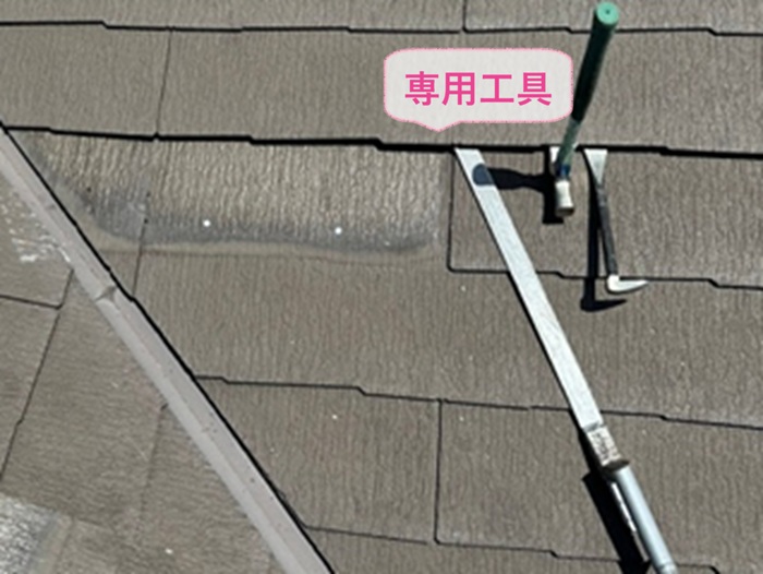 化粧スレートの差し替え補修で割れている屋根材を専用工具で撤去している様子