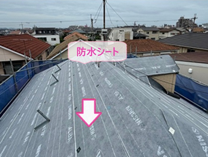 鳩小屋付きスレート屋根のカバー工法で防水シートを貼っている様子
