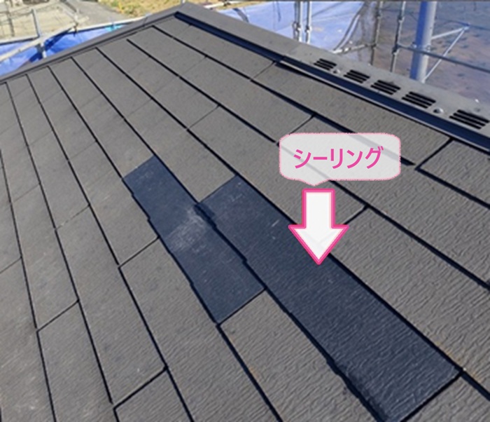 割れた化粧スレートの差し替えで新しい屋根材をシーリングで接着している様子