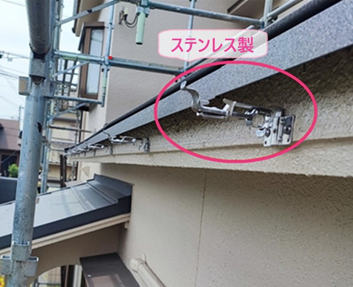 川西市の雨樋工事で新しくステンレス製の固定金具を取り付けている様子