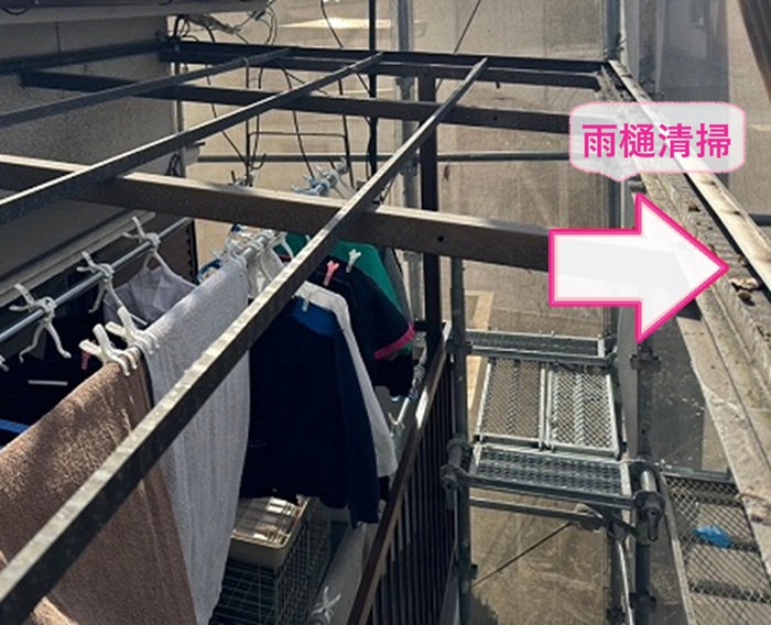 バルコニー屋根リフォームで雨樋内部を掃除している様子
