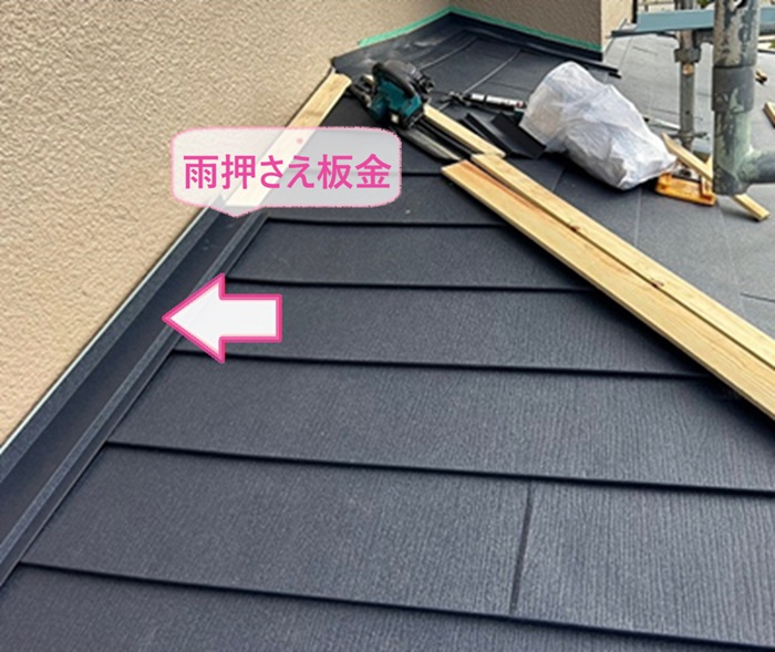 戸建ての重ね葺き工事で雨押さえ板金を取り付けている様子