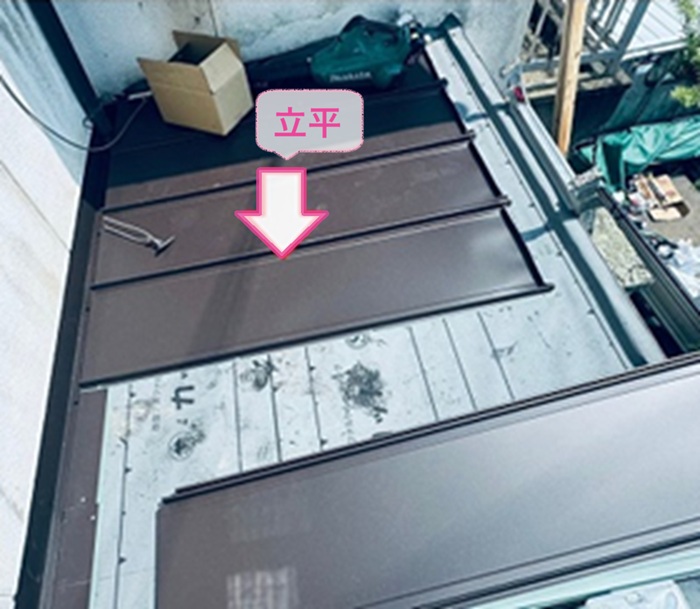 金属屋根の重ね張り工事で縦葺き鋼板の立平を葺いている様子