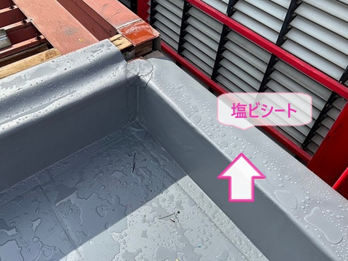 テナントビルの陸屋根金属改修で笠木部分を塩ビシート防水で覆っている様子