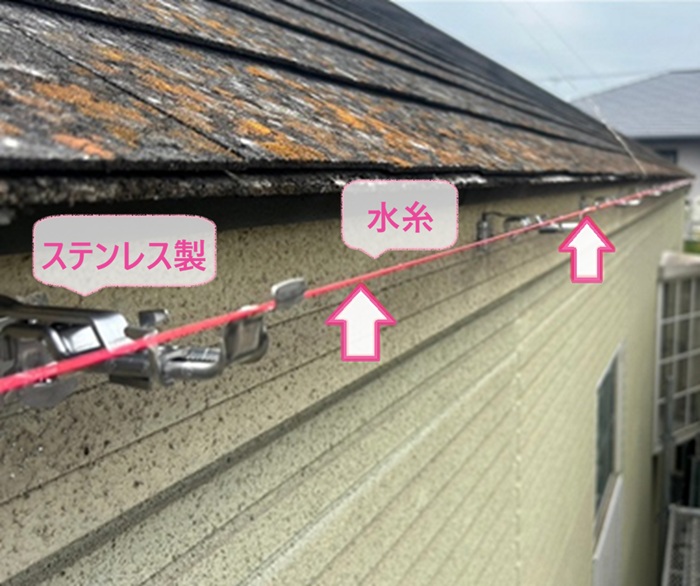 雹で割れた軒先排水部材の交換で新しくステンレス製の固定金具を取り付けている様子