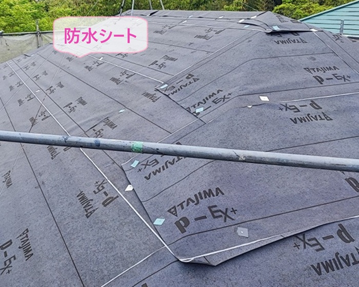 老朽化した化粧スレート屋根を重ね葺きで防水シートを貼っている様子