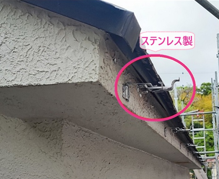 西宮市の雨どい交換工事で新しくステンレス製の固定金具を取り付けている様子