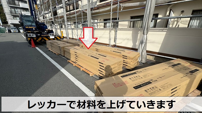 尼崎市での屋根重ね葺き工事でレッカーを使用して材料を上げている様子