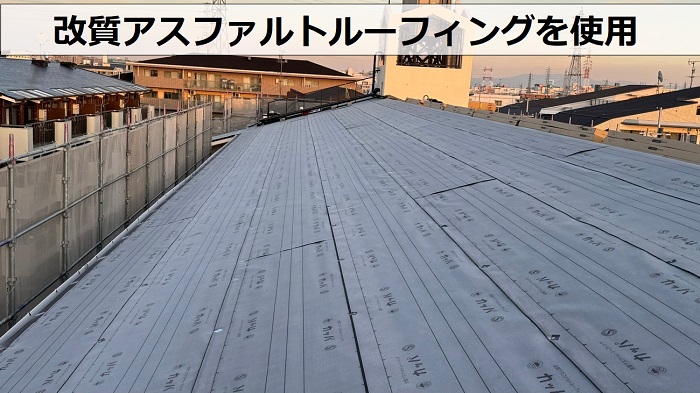 尼崎市の屋根重ね葺き工事で改質アスファルトルーフィングを貼っている様子