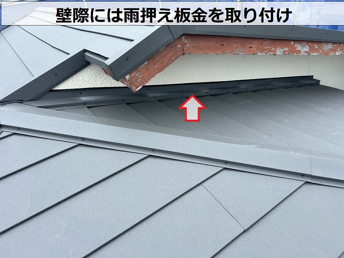 賃貸物件のスレート屋根改修工事で雨押え板金を取り付けている様子