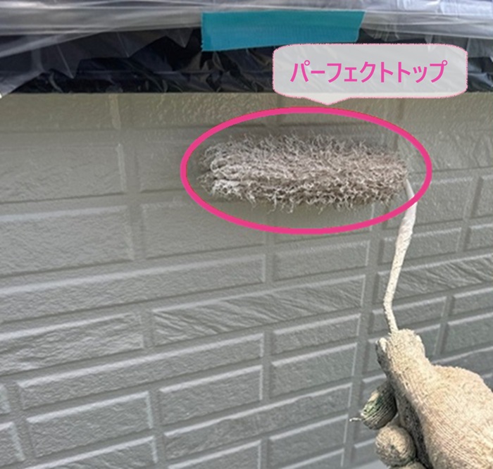 住宅外壁の塗り替えでパーフェクトトップを塗っている様子