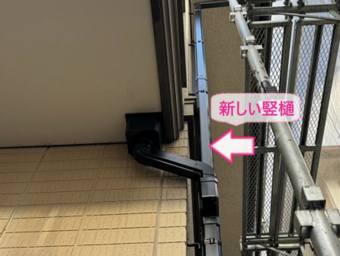 西宮市の雨樋交換で新しい竪樋を取り付けている様子