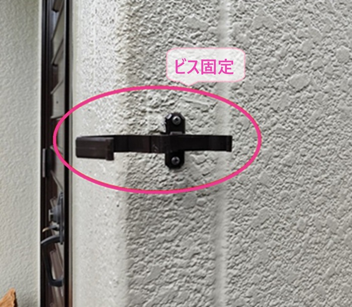老朽化した縦排水管の取り替えで新しい竪樋の固定金具をビスで固定している様子
