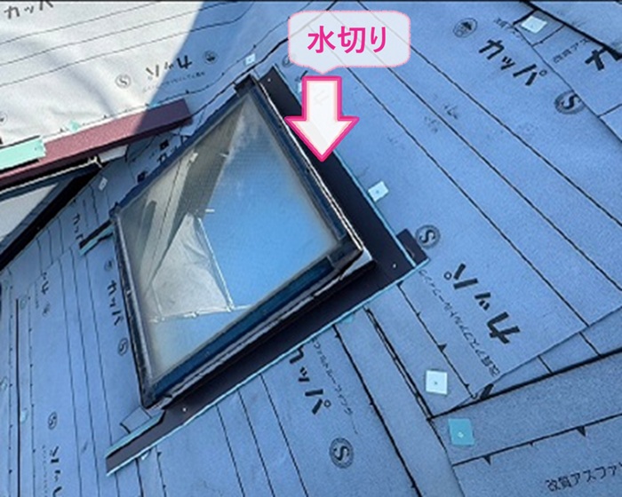 トップライト付き屋根の重ね施工で天窓まわりに水切りを取り付けている様子