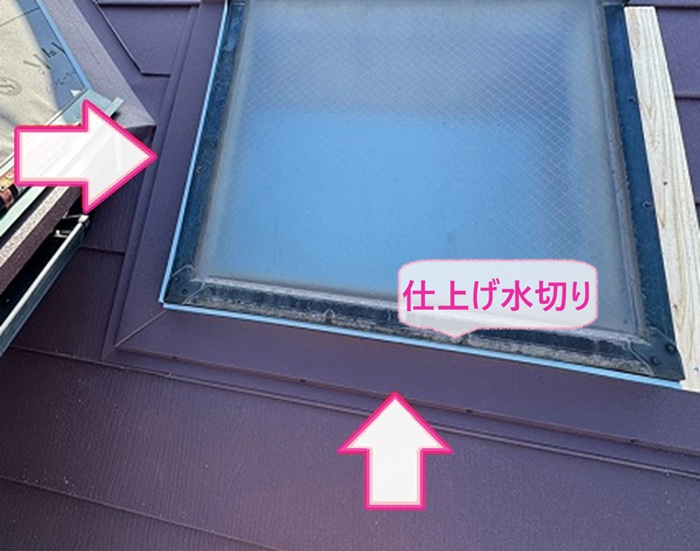 トップライト付き屋根の重ね施工で天窓まわりに仕上げ水切りを取り付けている様子