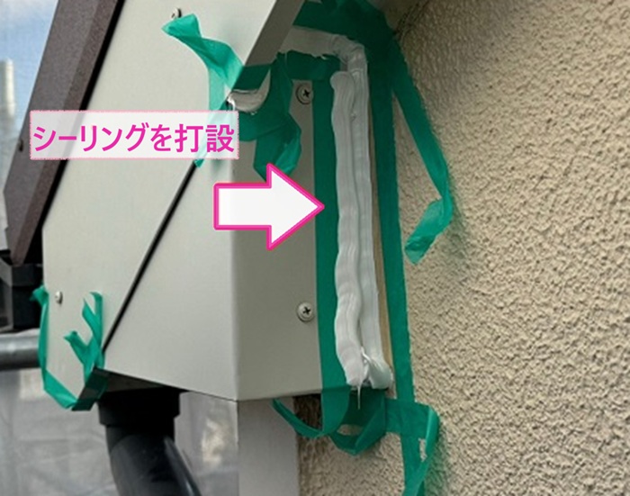 破風板の金属カバー工事で端部にシーリングを打設している様子